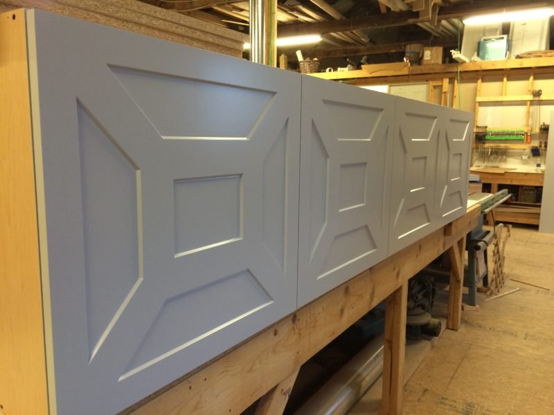 gray lacquered entertainment cabinet with cnc'ed doors